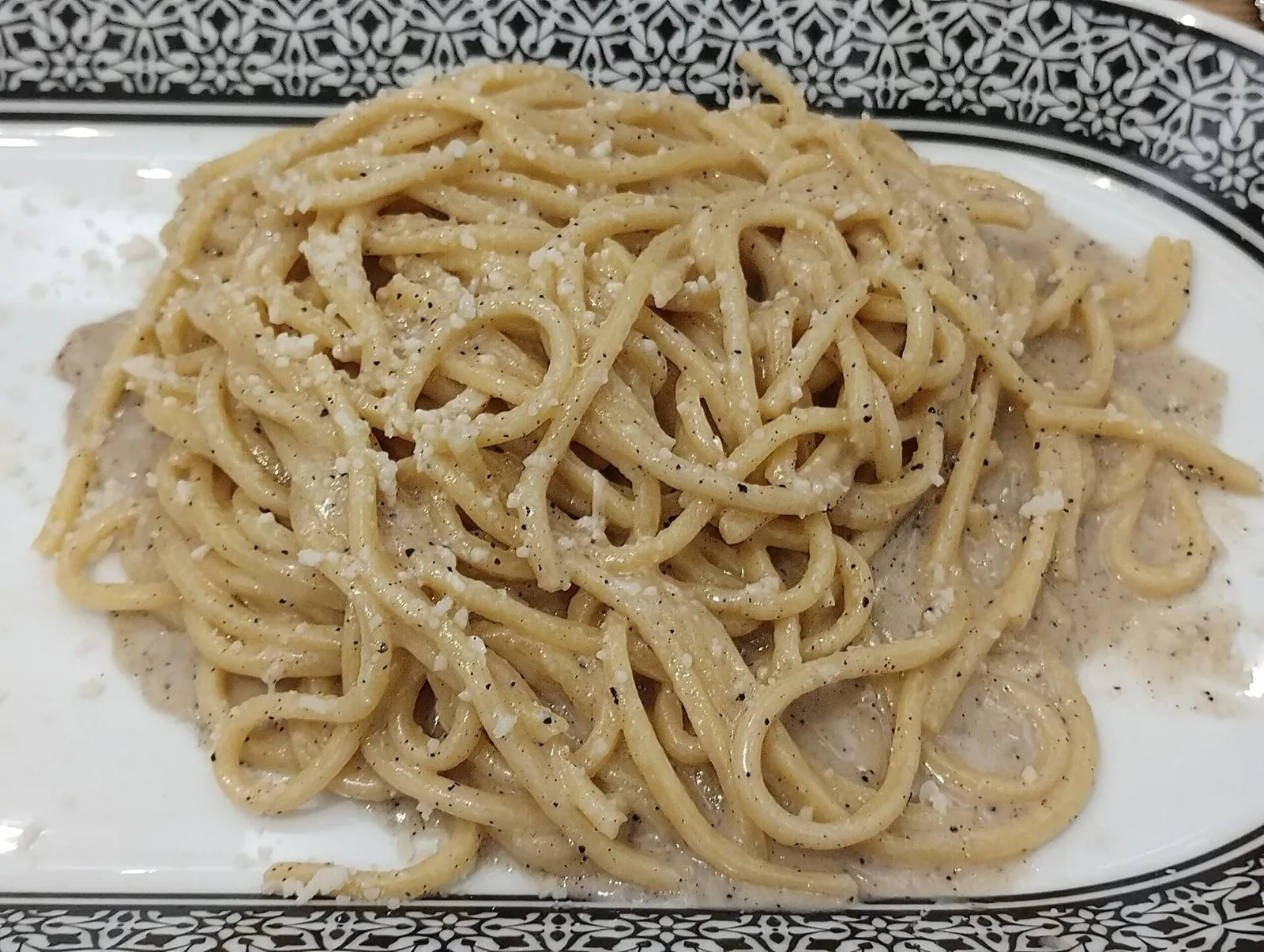 Un piatto di pasta cacio e pepe con pecorino e pepe nero